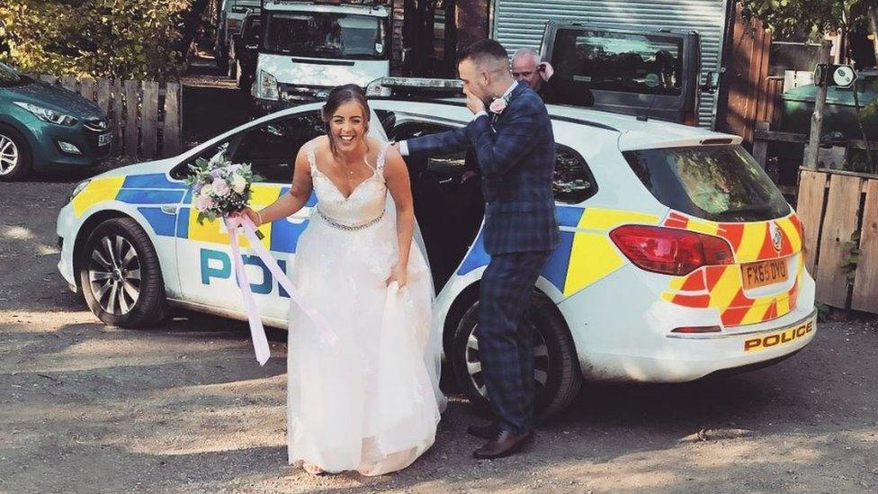 The newly weds getting out of a police car