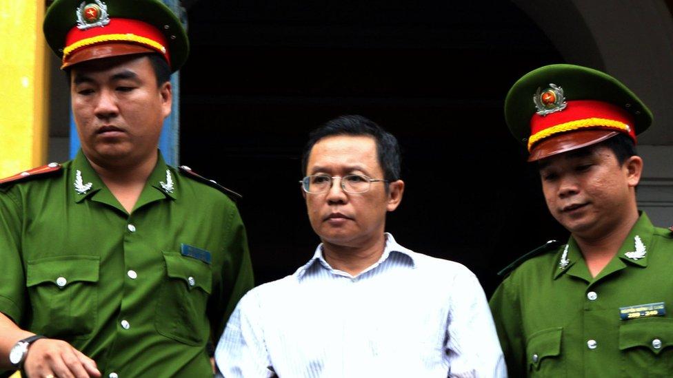 Pham Minh Hoang (C) being led out from the courtroom at the Ho Chi Minh City People's Court House on 10 August 2011.