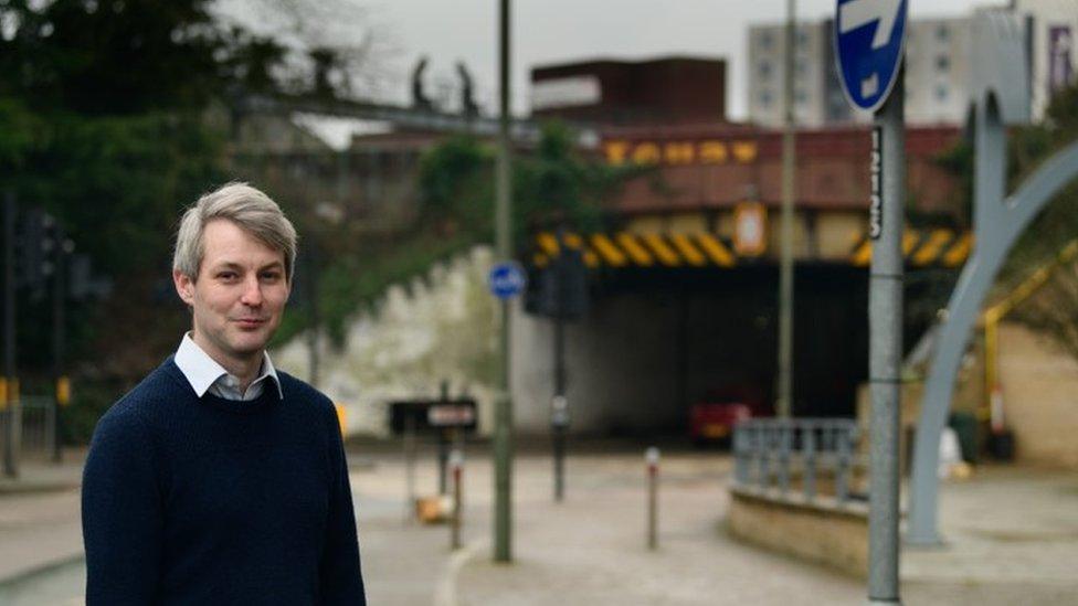 Cllr Will Forster standing in front of the existing Victoria Arch in Woking town centre.