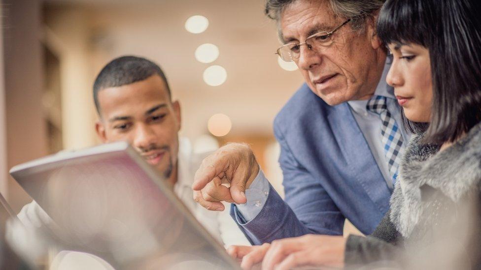 Business people looking at laptop