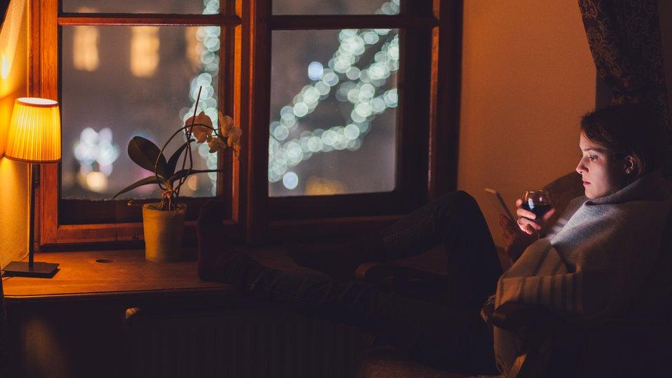 Woman drinking in cold dark room