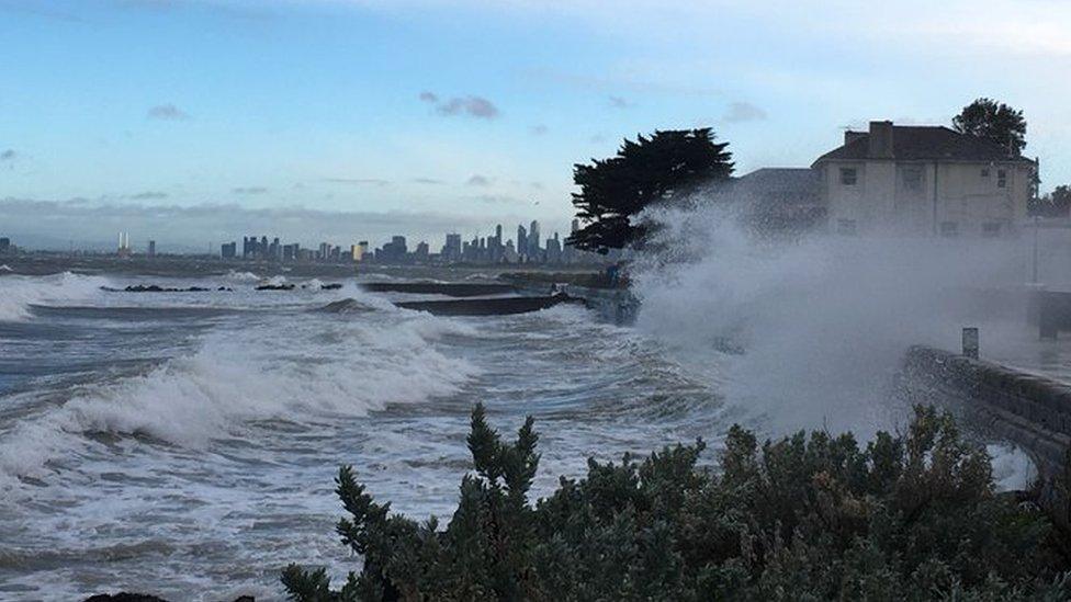 A sea swell breaks over a bike path at Brighton in Melbourne