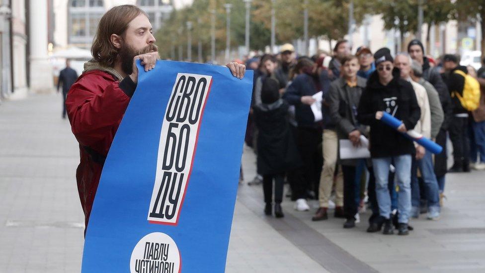 A man holds up a poster saying freedom for Pavel Ustinov on 18 Sept in Moscow