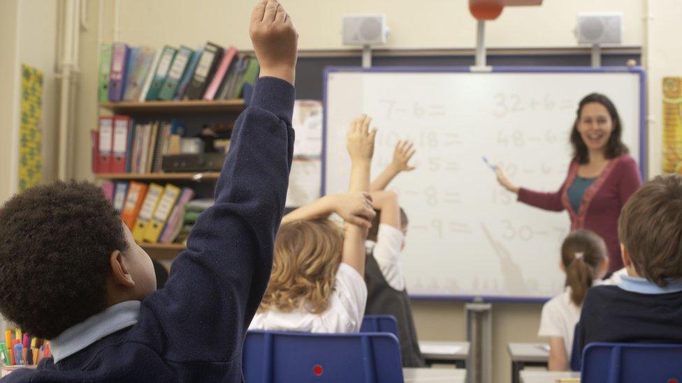 A teacher and school children learn in the classroom