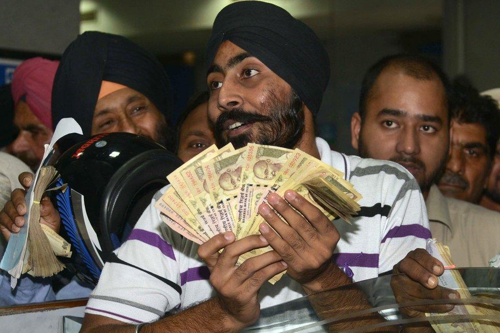 Indian bank customers wait to deposit 500 and 1000 Indian currency notes at a bank in Amritsar on November 10, 2016