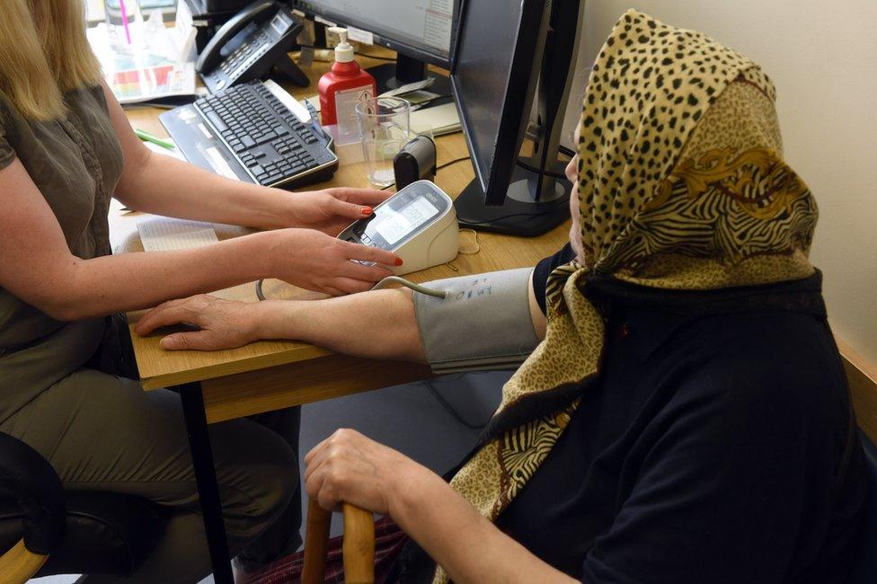 Doctor measuring old lady's blood pressure