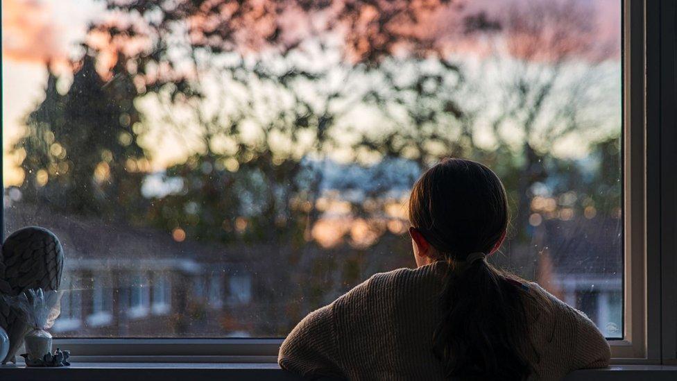 Girl looking out window