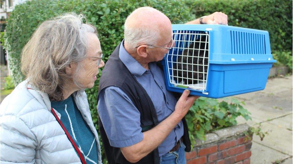 William Earp and Martha Street holding the cat carrier with Nutmeg inside