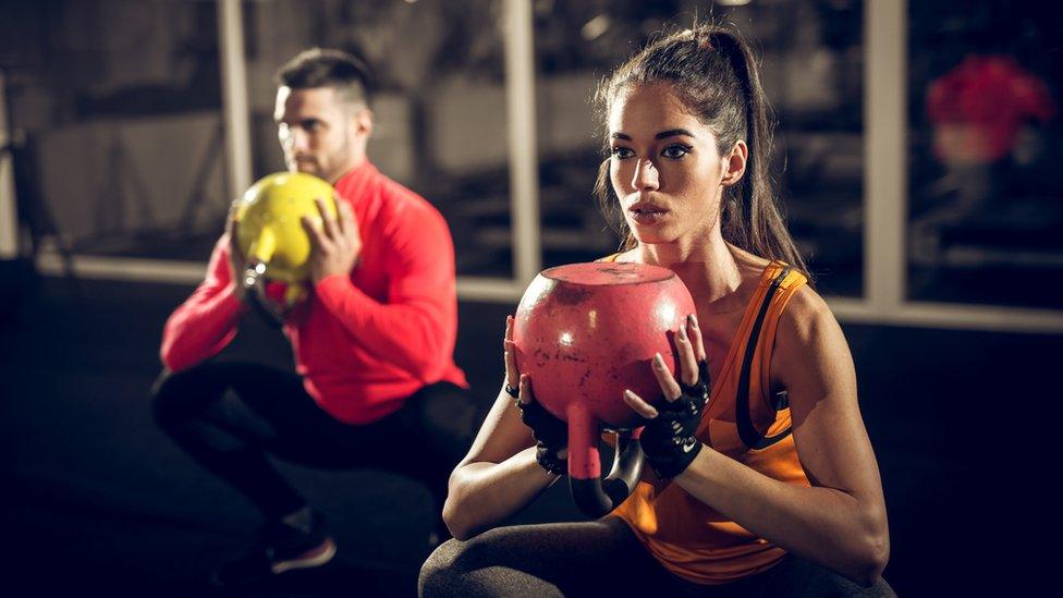 Young couple exercising with weights