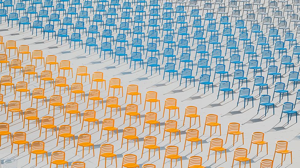 Rows of deserted brightly coloured empty chairs at a school