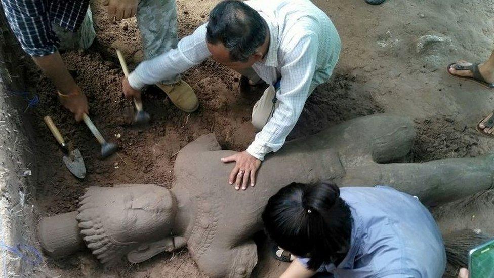 Archaeologists excavating the sandstone statue at the Angkor Wat temple complex in Siem Reap province (01 August 2017)