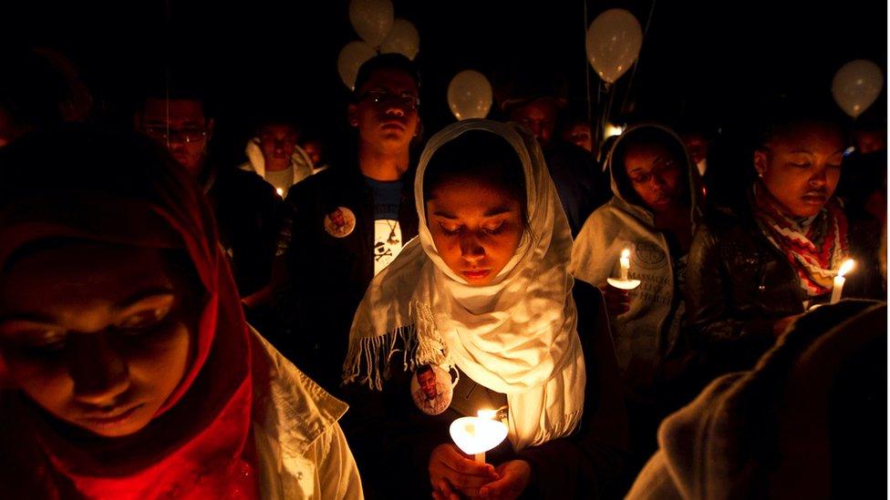 People at a vigil hold candles