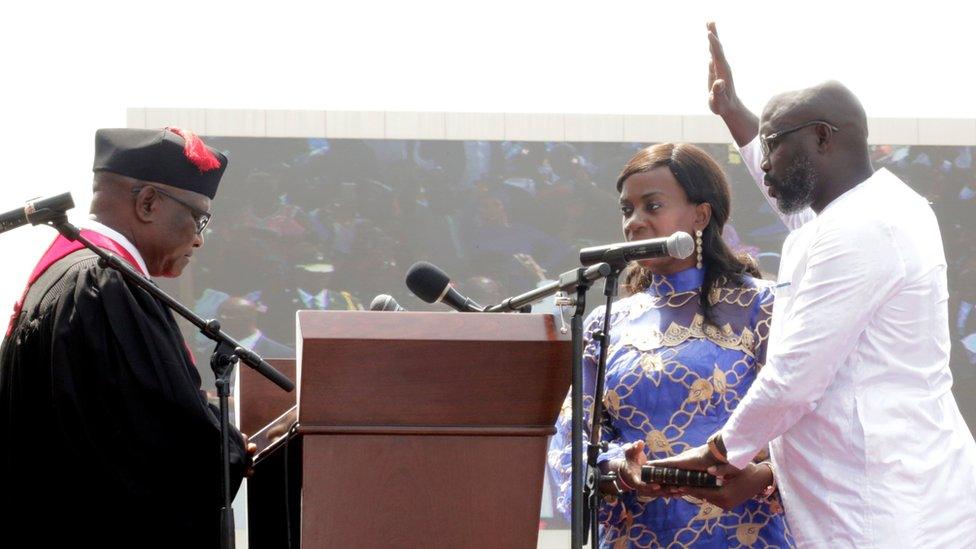 Liberia's new President George Weah raises his hand during the swearing-in ceremony at the Samuel Kanyon Doe Sports Complex in Monrovia, Liberia, January 22, 2018.