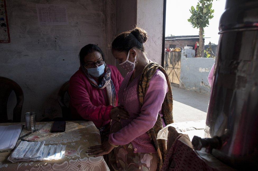 Kiran Mal, a female health worker, attending to a patient in Uttarakhand