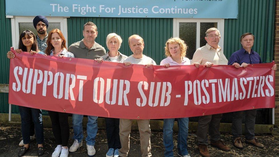 Cast of Mr Bates vs the Post Office holding banner from the drama