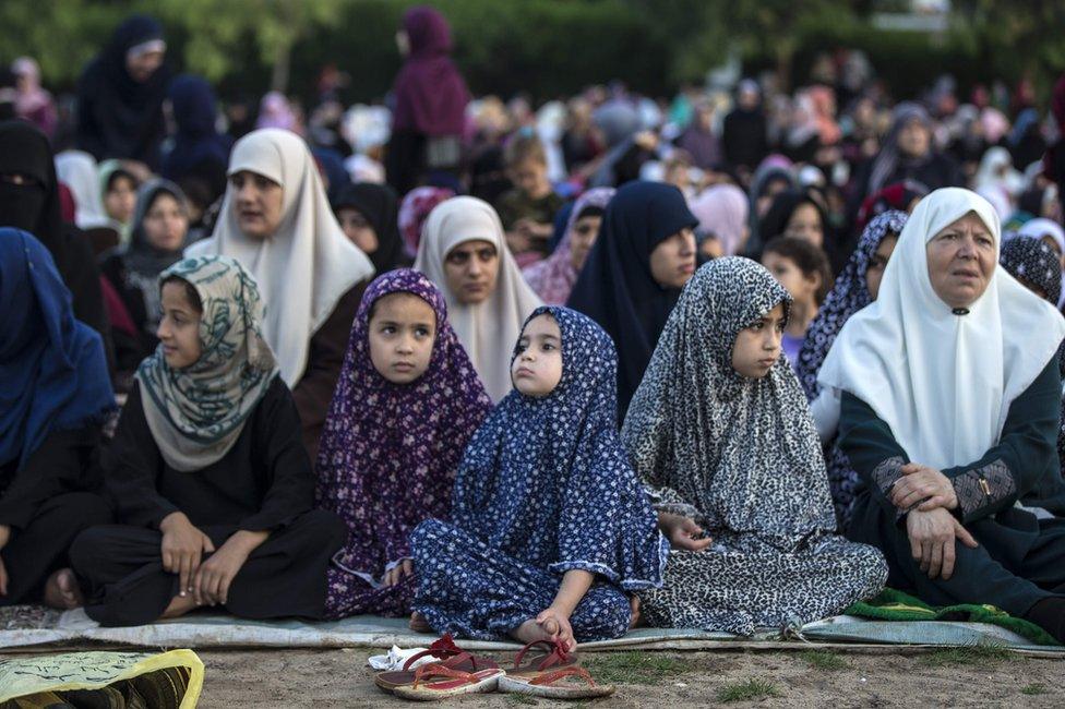 Palestinian Muslims attend the Eid al-Fitr prayer in an open area of Gaza City, 25 June