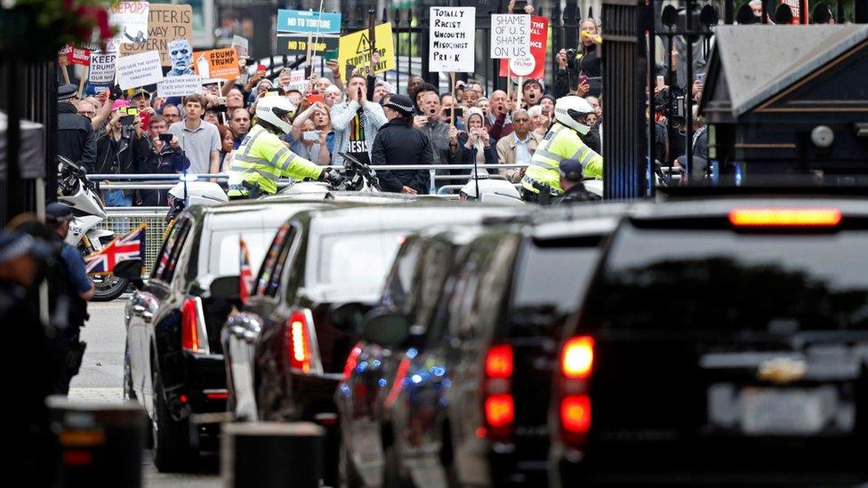 Demonstrators at Downing Street watch motorcade leave