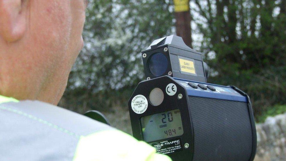 A man holding a speed gun