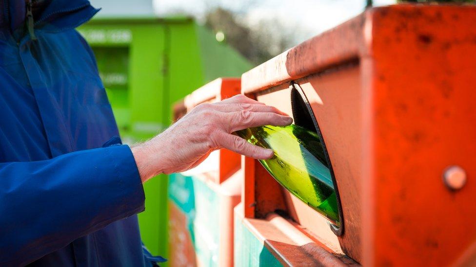 Man recycling glass at the recycling bins - stock photo