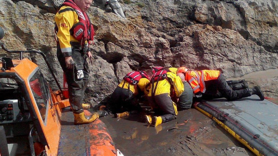 Rescuers struggle to free the man from the quicksand