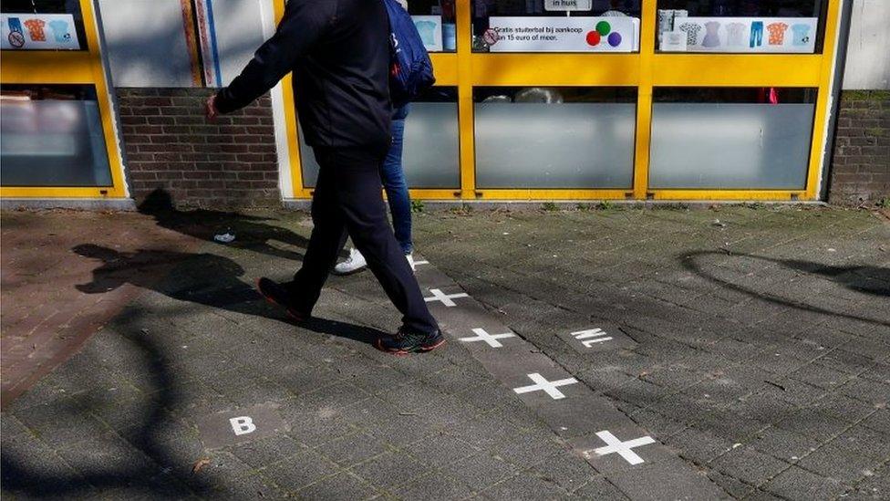 A couple crosses the border between Belgium and the Netherlands in Baarle on 26 March