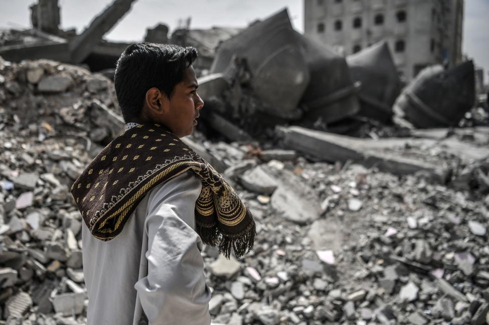 A child is seen as Palestinians perform Friday prayers among the rubble of the Al-Farooq Mosque, destroyed in an Israeli attack on 1 March 2024 in Rafah, Gaza.