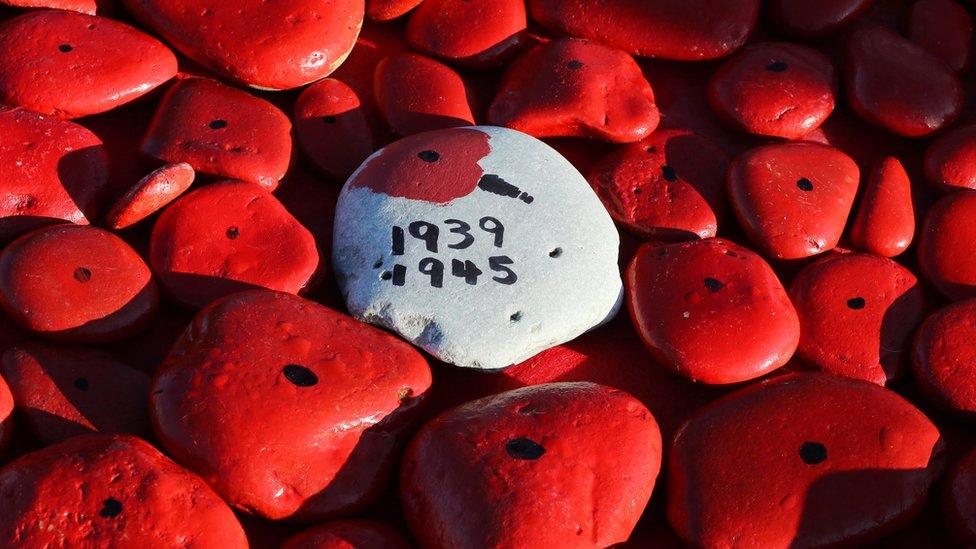 Some of the hundreds of hand-painted pebbles at the foot of the Tommy Statue in Seaham, County Durham