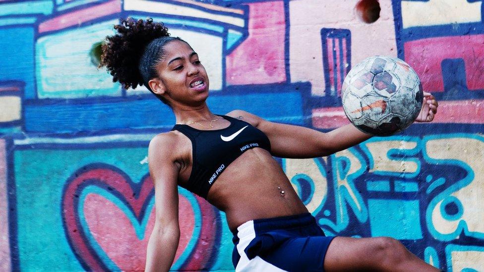 Girls kicks a ball in the favela