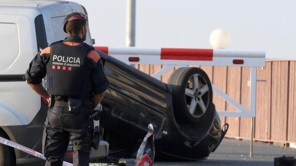 Policemen check the car involved in the attack in Cambrils