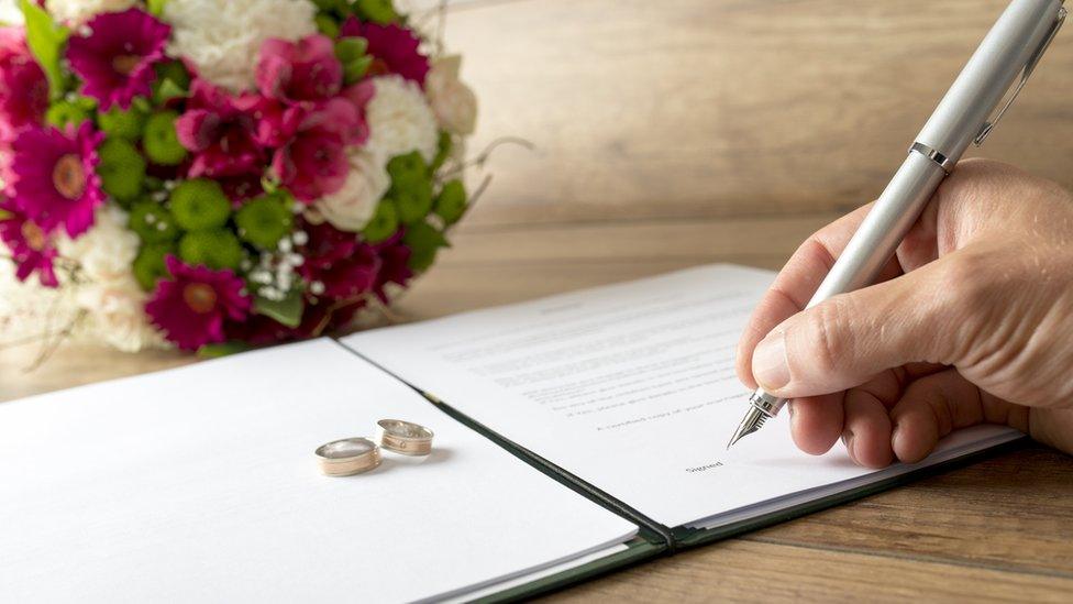 Man signing a marriage register