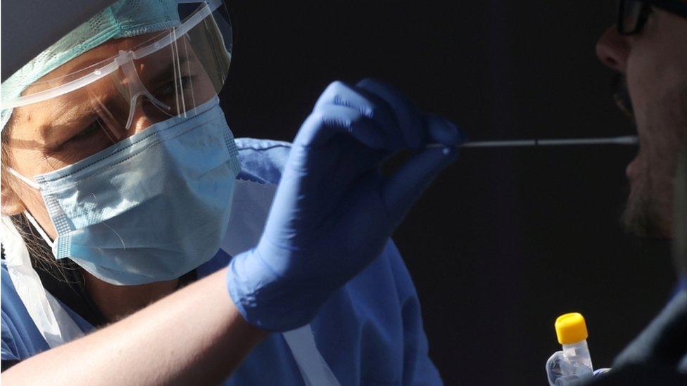 Medic carries out a swab test on a person in a car