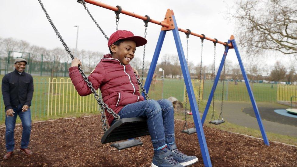 boy-on-swing-in-park.