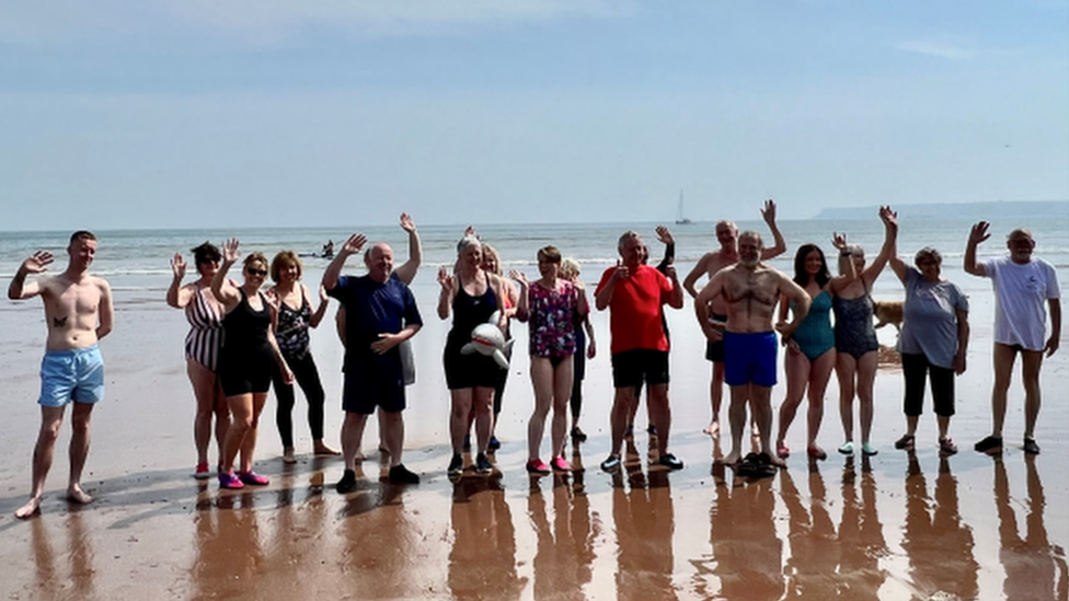 Group photo on the sand in front of the sea