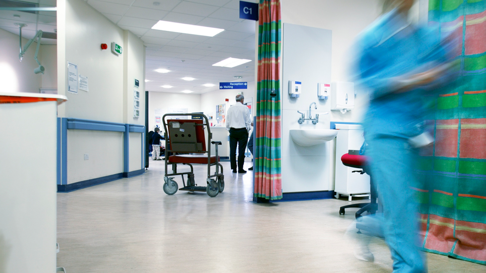 A wheelchair sits in a hospital corridor