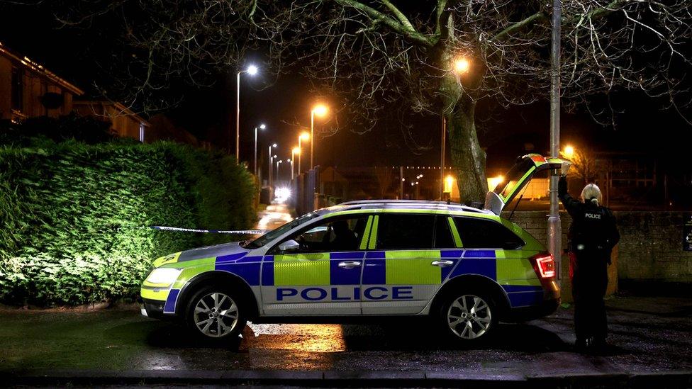 Female officer closing boot of police vehicle