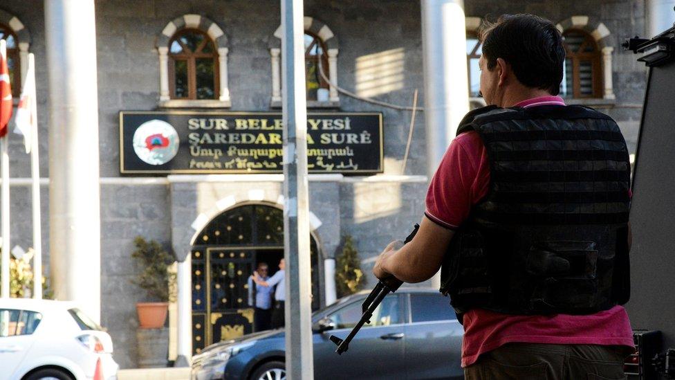 Turkish policeman stands guard outside a Sur municipality building in Diyarbakir Turkey on 11 September 2016