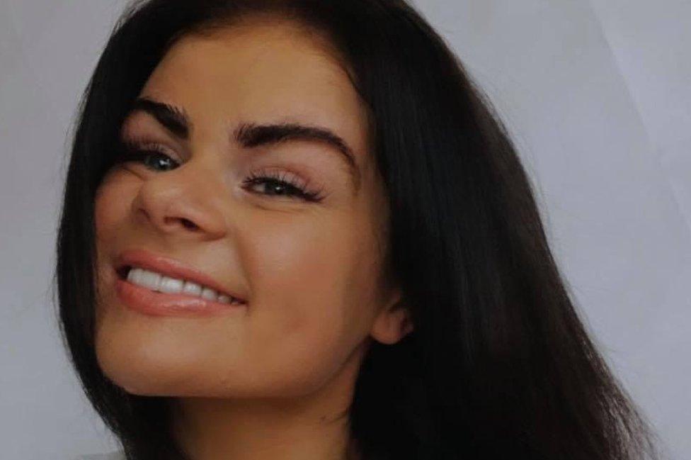 A woman with brown hair smiles at camera