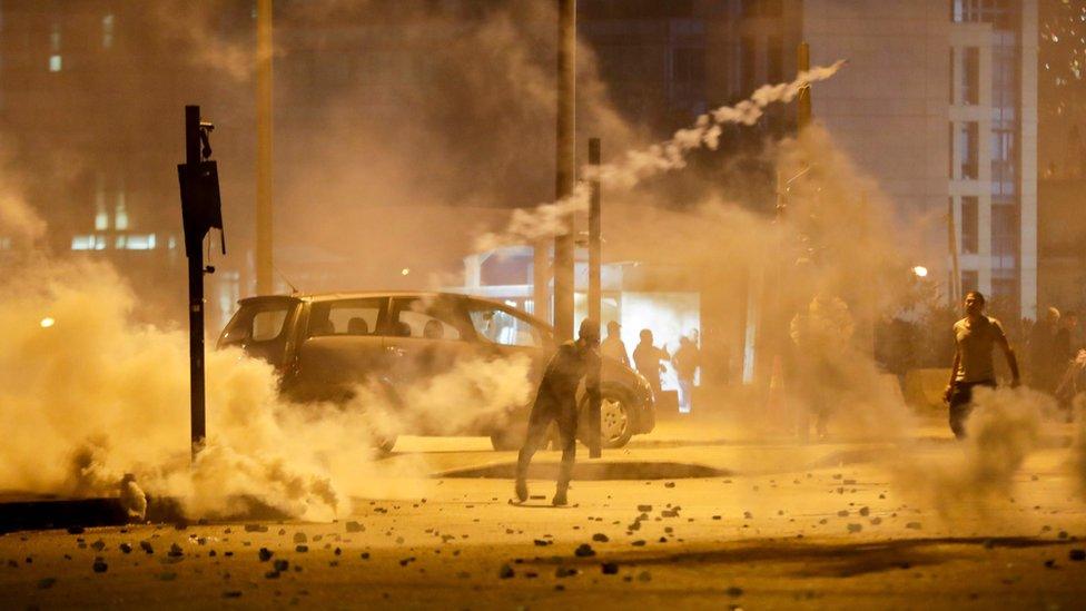 Lebanese demonstrators hurl tear-gas canisters back at riot police during clashes in the capital Beirut