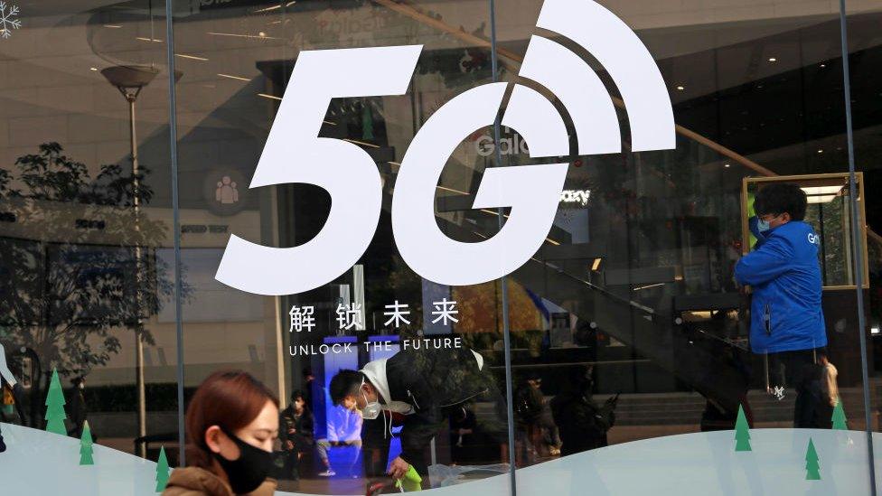 A pedestrian walks past a 5G logo on the window of a Samsung store on February 24, 2020 in Shanghai, China.