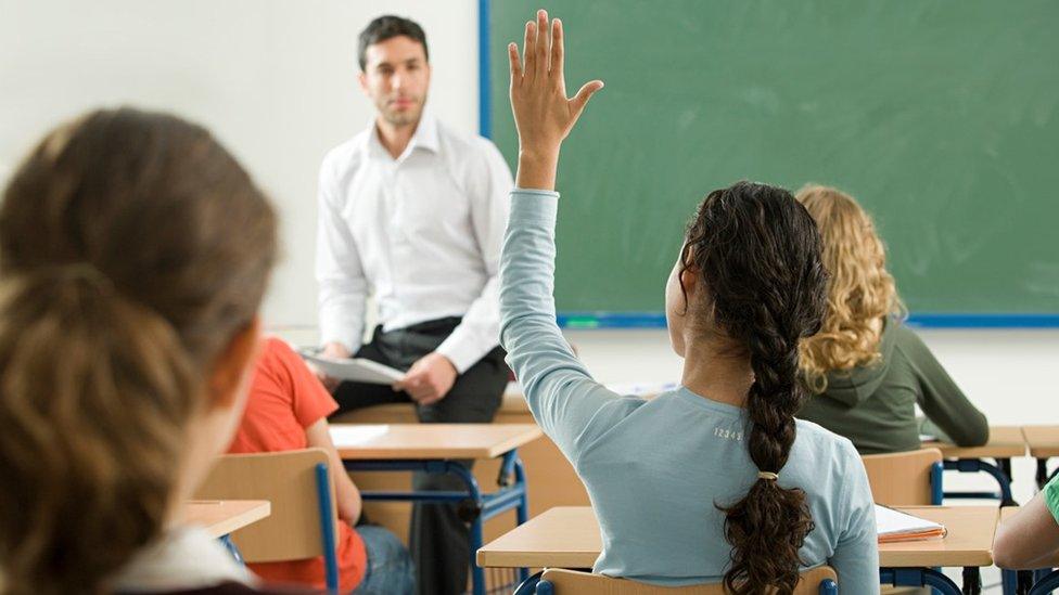 Pupil raising their hand in class