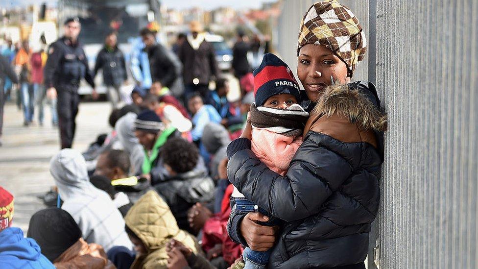 Immigrants wait for a ferry in Lampedusa, southern Italy