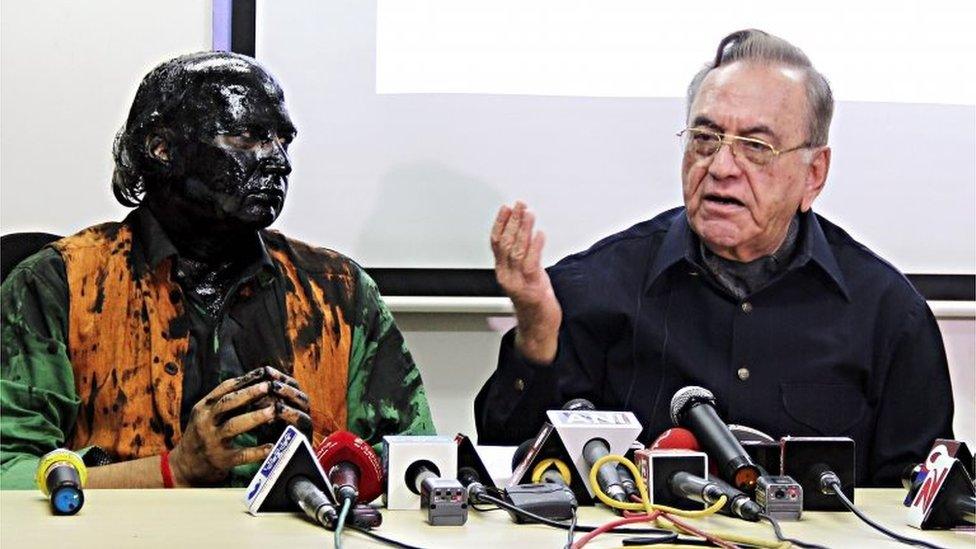 Indian activist Sudheendra Kulkarni (L), whose face was blackened by ink in an alleged attack, looks on as former Pakistani foreign minister Khurshid Mahmud Kasuri speaks to media in Mumbai on October 12, 2015.