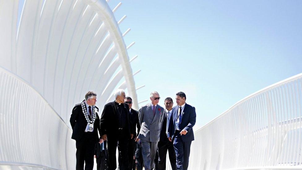 Prince Charles talks with officials as he walks across the Te Rewa Rewa bridge