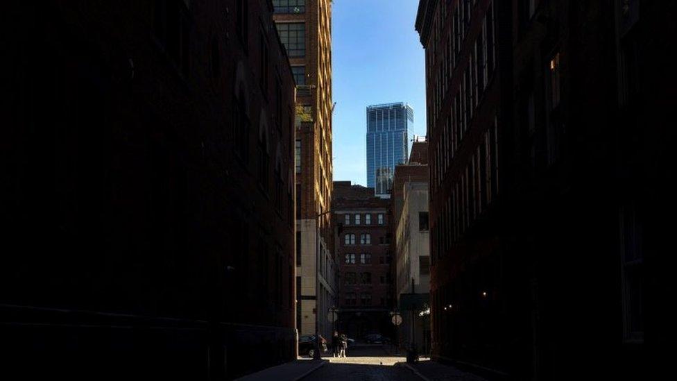 A mother and son walk down an empty Collister Street in Tribeca