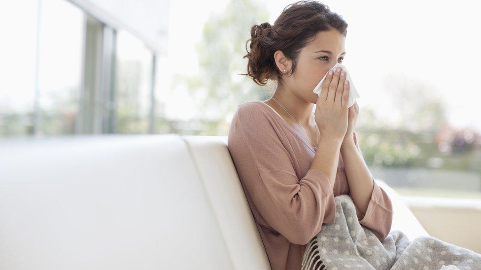 A woman blowing her nose