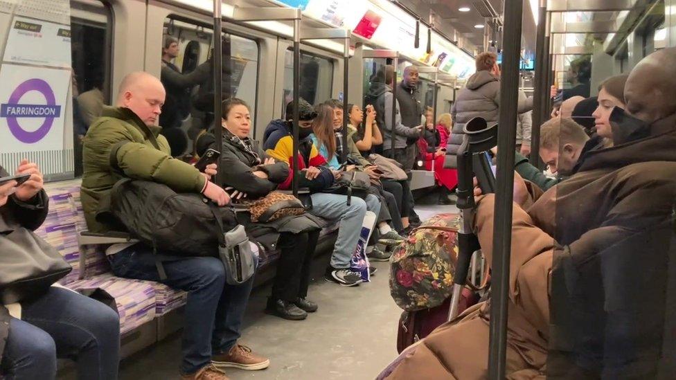 An image taken by a passenger on board the Elizabeth line at Farringdon station, showing a busy service with lots of luggage.