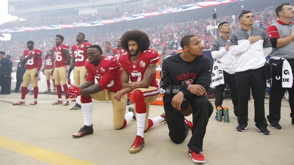 Eli Harold, Colin Kaepernick and Eric Reid kneel during the American national anthem before a San Francisco 49ers v New York Jets game in December 2016