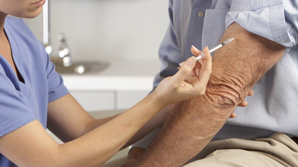 Doctor injecting patient with syringe