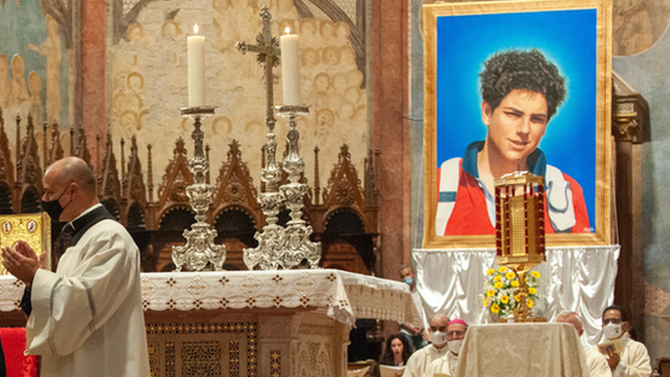 Cardinal Agostino Vallini greets the mother and father of Carlo Acutis as he celebrates Mass for the beatification process