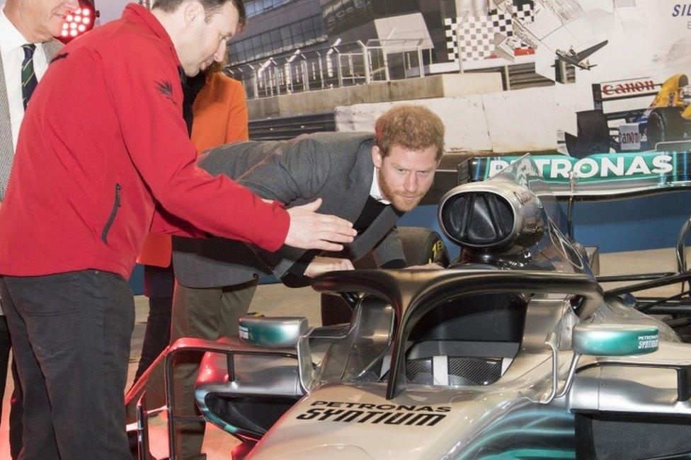 Prince Harry, studies the "Halo" on Lewis Hamilton"s Mercedes, a new safety addition to Formula 1 cars this year, during a visit to the Silverstone Circuit in Northamptonshire